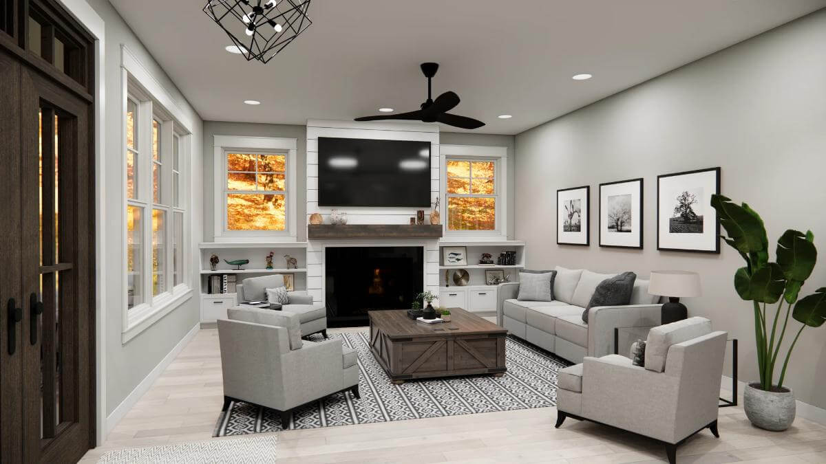 Great room with gray seats and a fireplace topped by a TV.