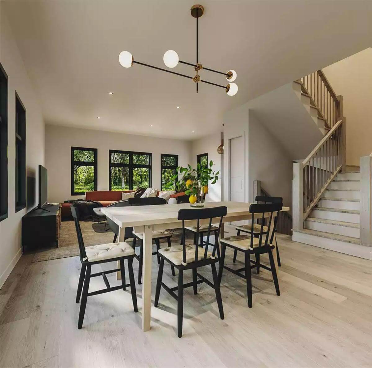 Dining area with a light wood table surrounded by cushioned chairs.