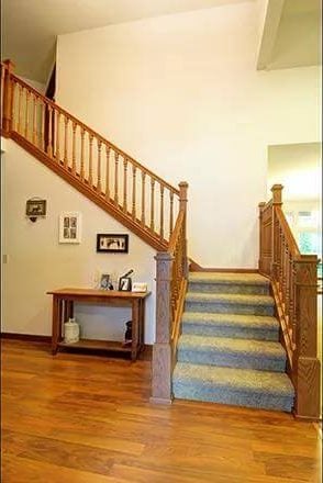 Foyer with a carpeted staircase complemented by a console table.
