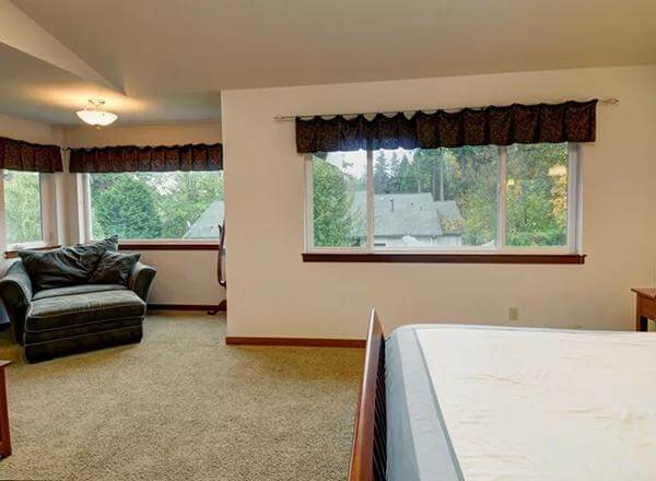 Primary sitting area with a lounge chair and large windows.