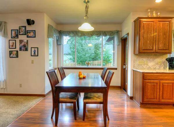 Dining area with a dark wood dining set illuminated by a warm pendant light.