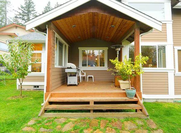Covered patio with white-framed windows and a vaulted ceiling clad in wood planks.
