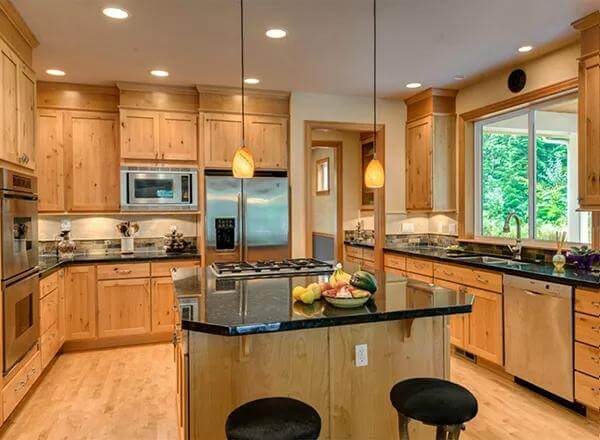 Kitchen with a cooktop island and wooden cabinets that blend in with the hardwood floor.