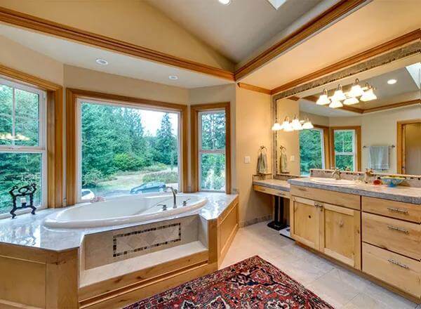 Primary bathroom with a large vanity, a makeup counter, and a deep soaking tub against the bay window.