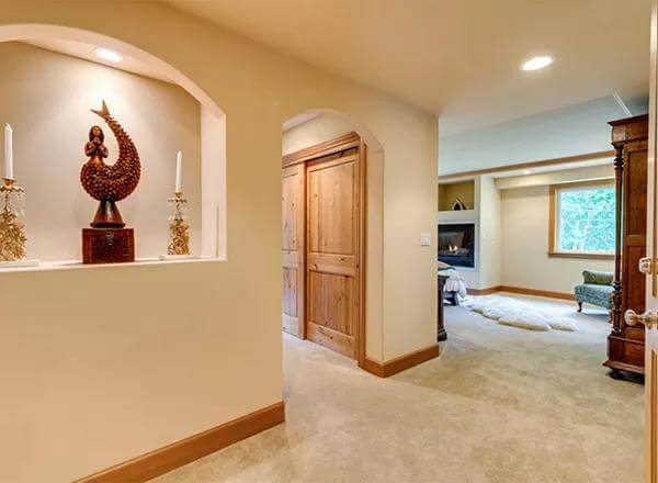 Foyer with a carpeted floor and an arched opening leading to the living room.