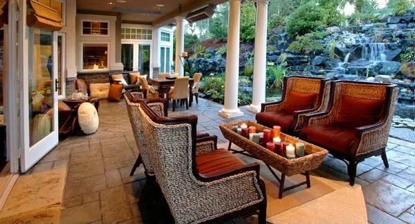 Covered patio with wingback chairs and an outdoor dining set.