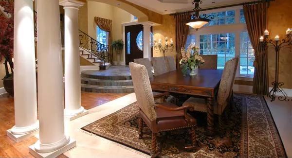 Dining room with a dark wood dining set illuminated by a warm pendant light.