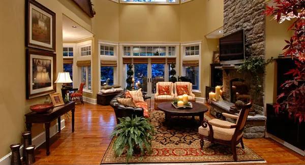 Family room with cushioned chairs, a round coffee table, and a stone fireplace.