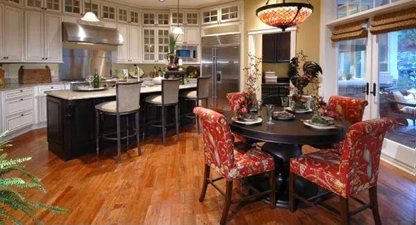Kitchen and breakfast nook with white cabinetry, a contrasting island, and a round dining set.