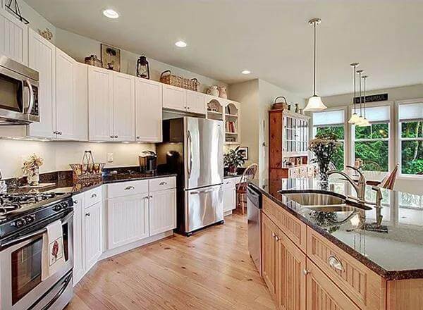 The kitchen includes stainless steel appliances and double sinks fitted on the island.