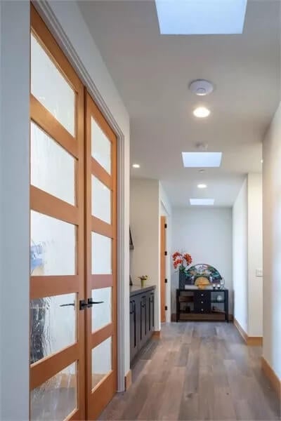 Hallway with a French door and skylights.