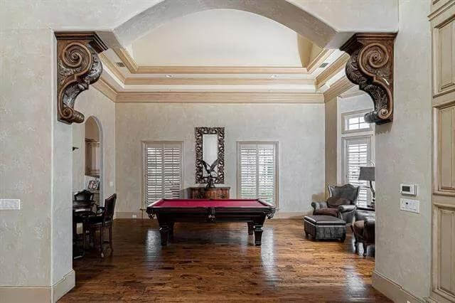 Living room with wingback chairs and a billiards table.