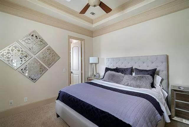 Bedroom with a tufted bed under a tray ceiling.