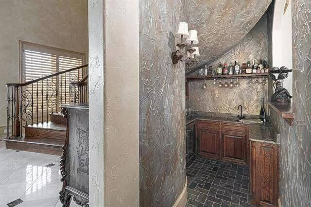 Wet bar with wooden cabinets and granite countertops.