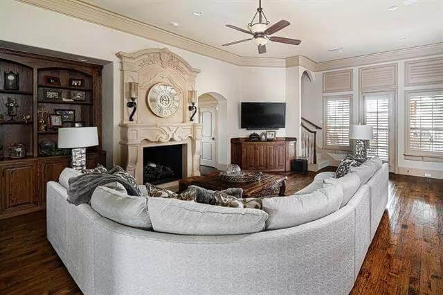 Family room with a curved sofa, a fireplace, and a wall-mounted TV.