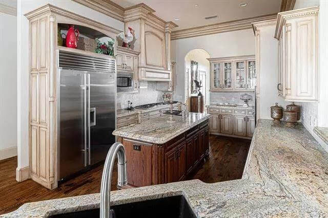 Kitchen with white cabinets, a center island, and angled peninsula.