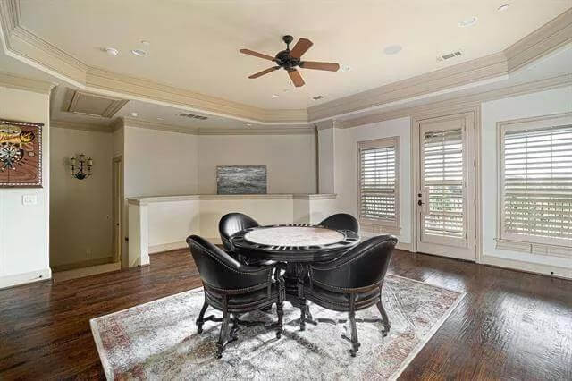Game room with a poker table, louvered windows, and a matching door that opens to the balcony.