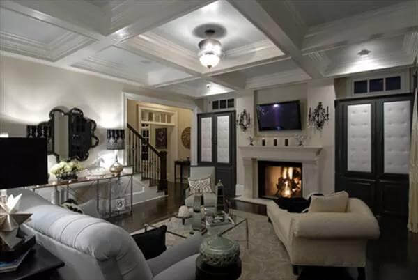 Living room with a coffered ceiling and a fireplace topped by a TV.