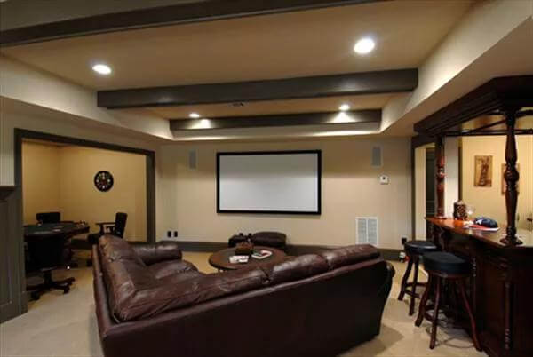 Media room with a wet bar and a leather sofa under a beamed ceiling.