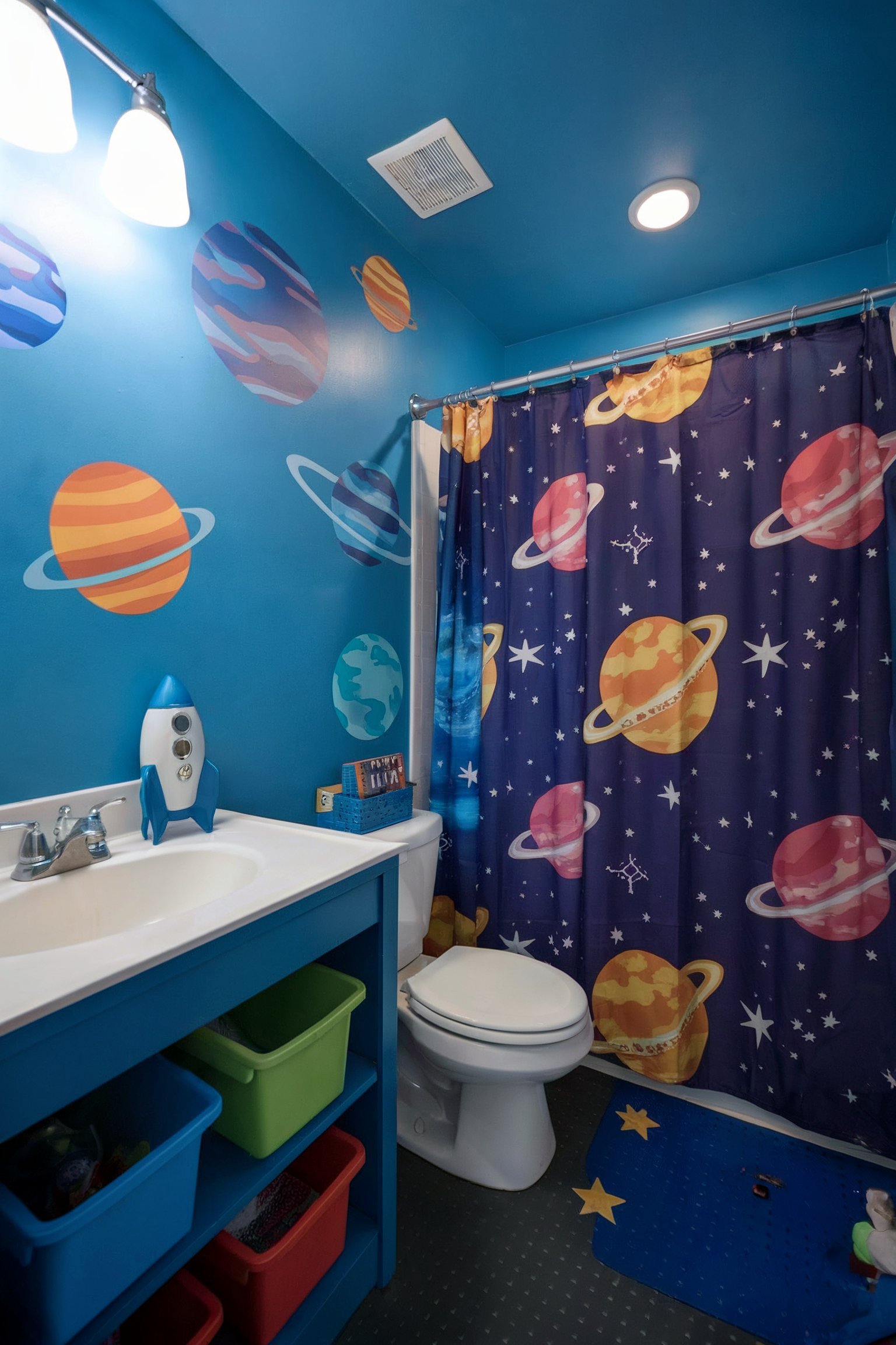A space-themed bathroom with bright blue walls, planet decals, and a matching shower curtain
