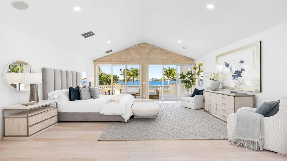 Bedroom with a large bed, sliding glass doors and hardwood floors.