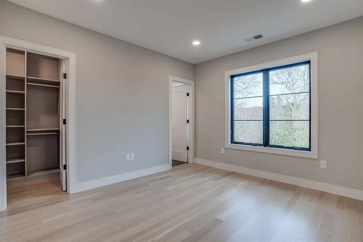 Bedroom with glass windows and hardwood floors.