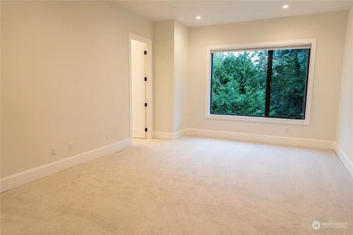 Bedroom with glass windows and carpet flooring.