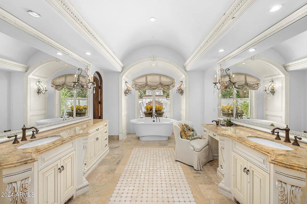 Bathroom with dual custom-made vanity and a soaking tub.