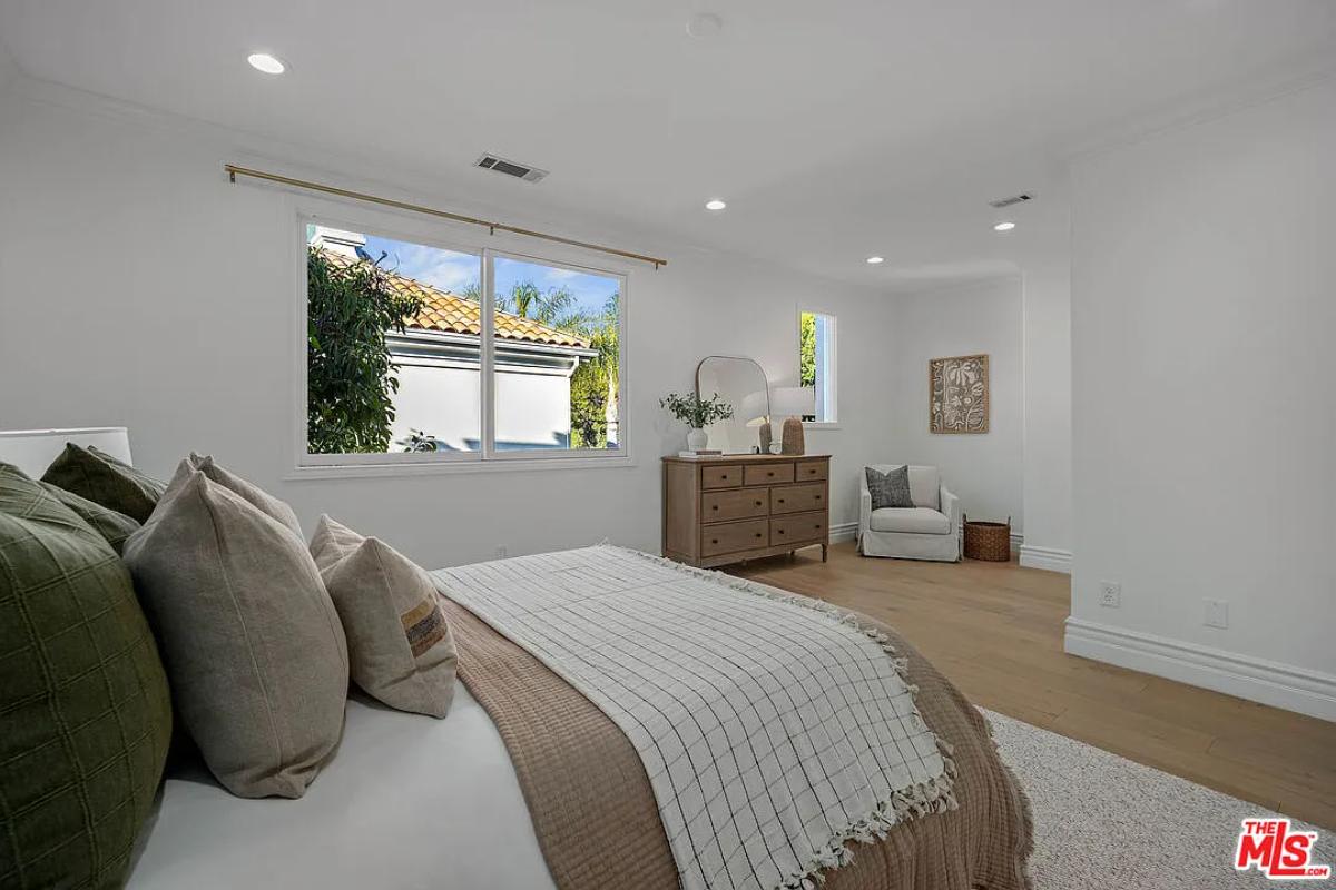 Bedroom with a large bed and hardwood floors.
