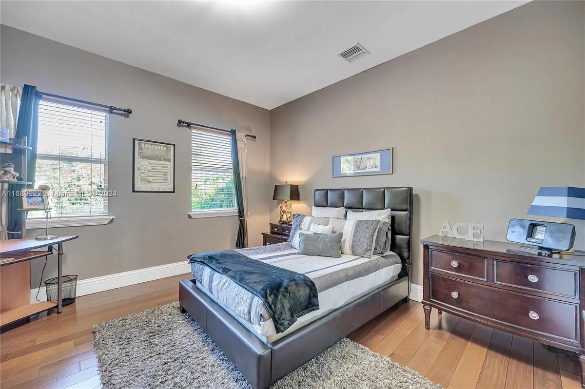 Bedroom with a large bed and hardwood floors.