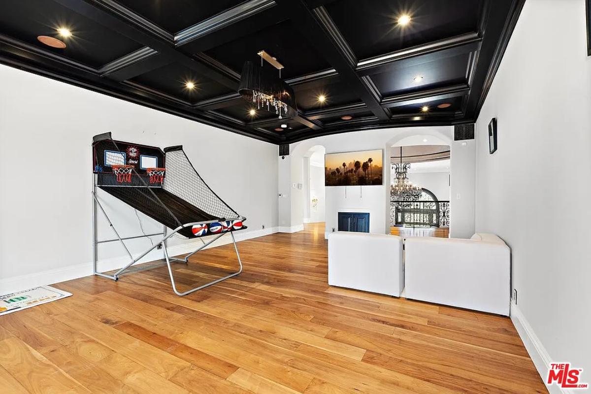 Recreation room with hardwood floors and coffered ceilings.