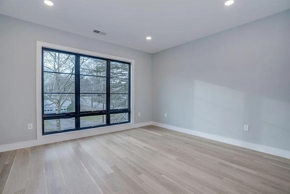 Bedroom with glass windows and hardwood floors.