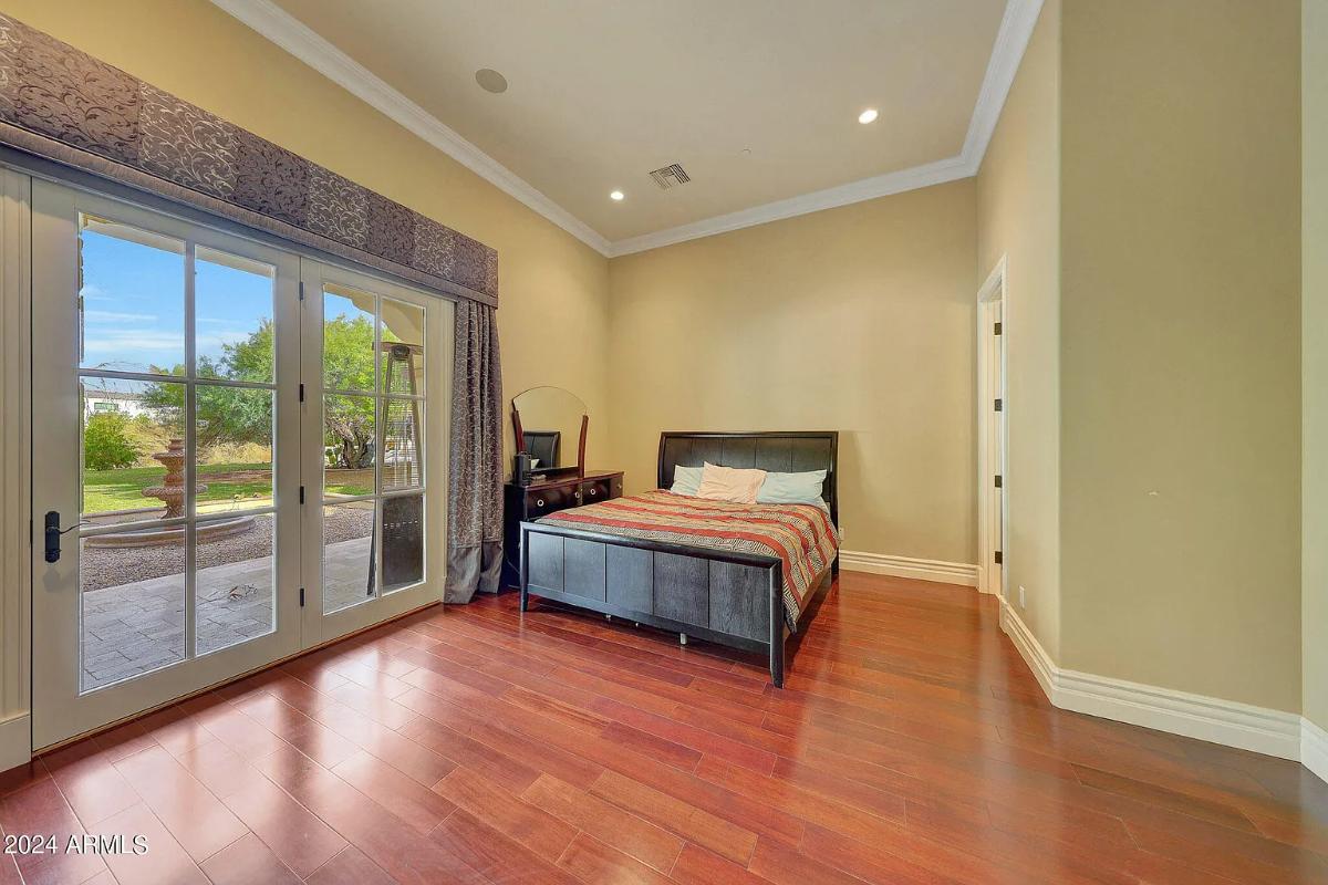 Bedroom with a large bed and hardwood floors.
