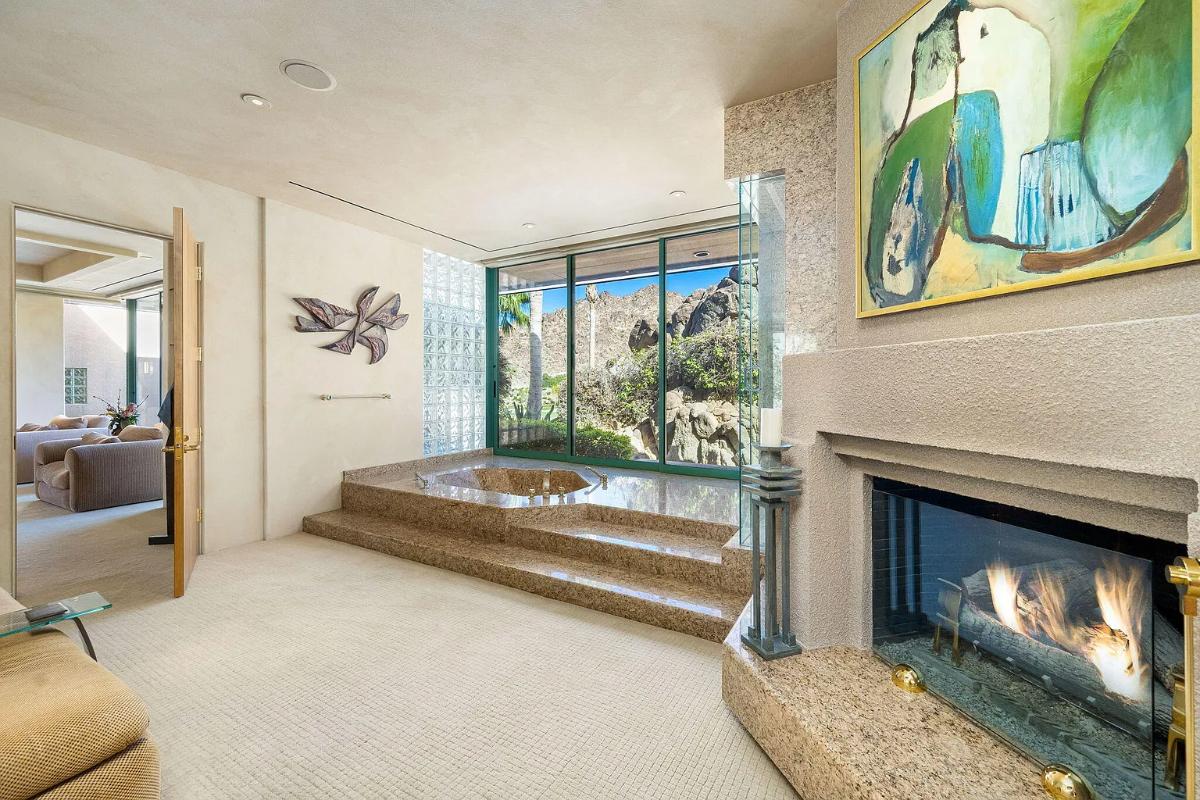 Bathroom with a soaking tub and a fireplace.