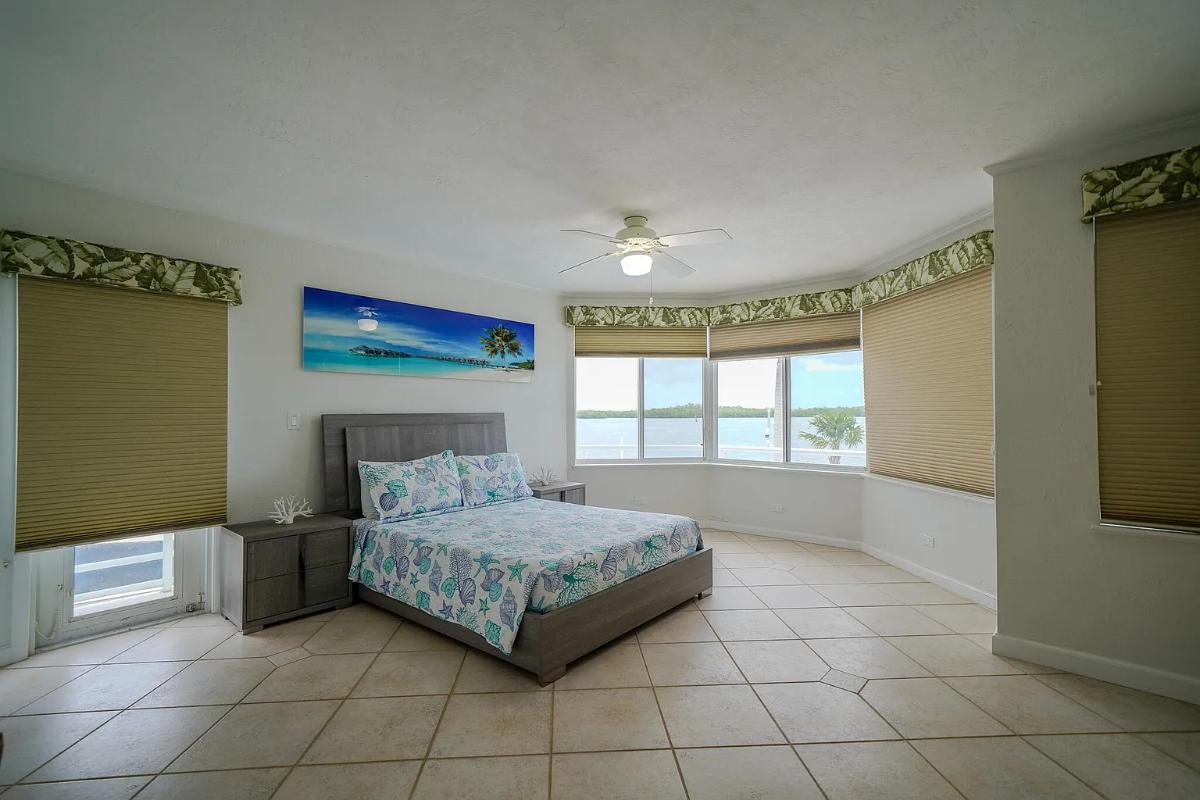 Bedroom with a large bed and glass windows.