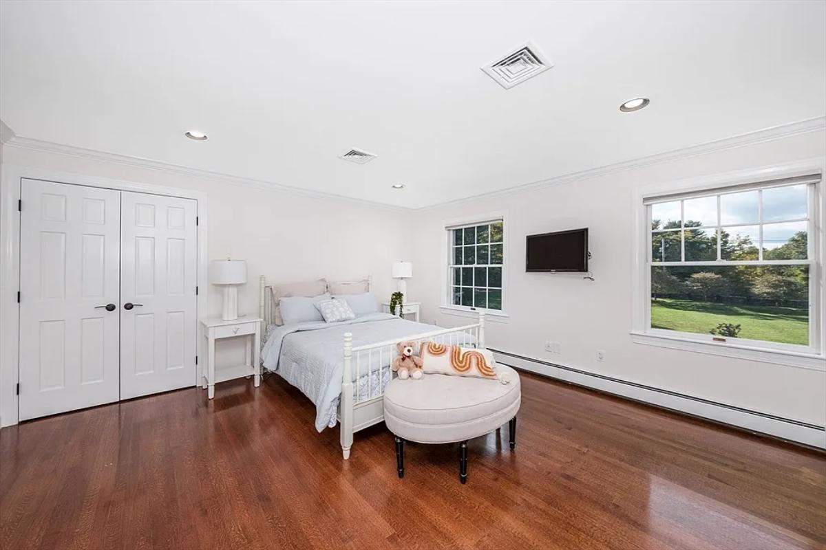 Bedroom with a large bed and hardwood floors.