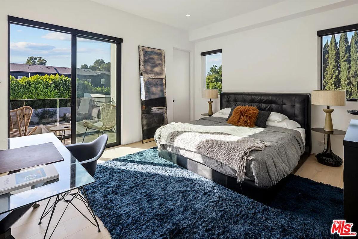 Bedroom with a large bed and sliding glass doors.