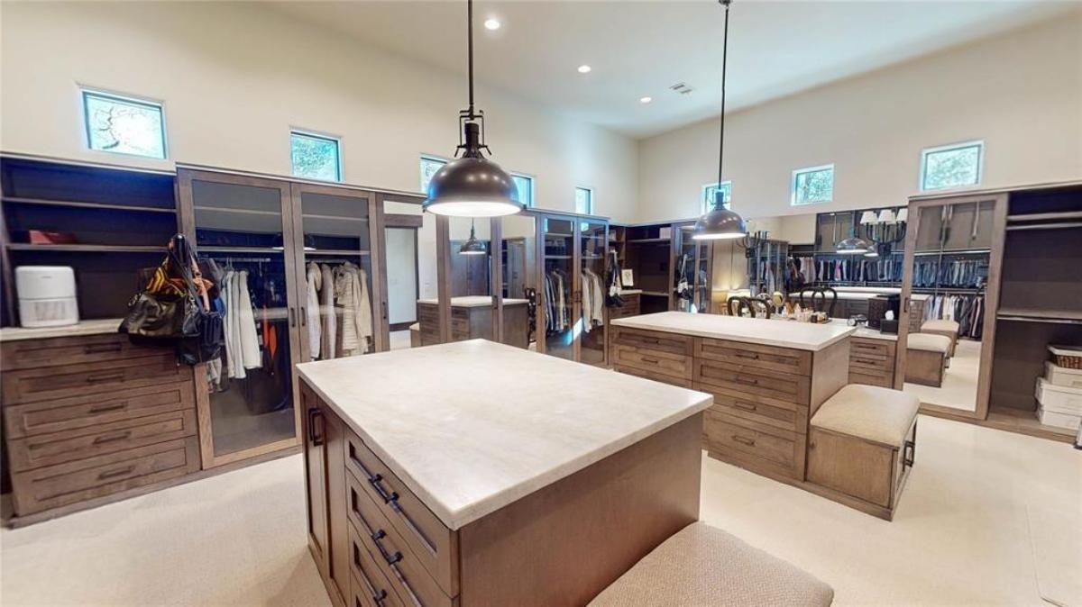 Walk-in closet with custom cabinetry and shelves.