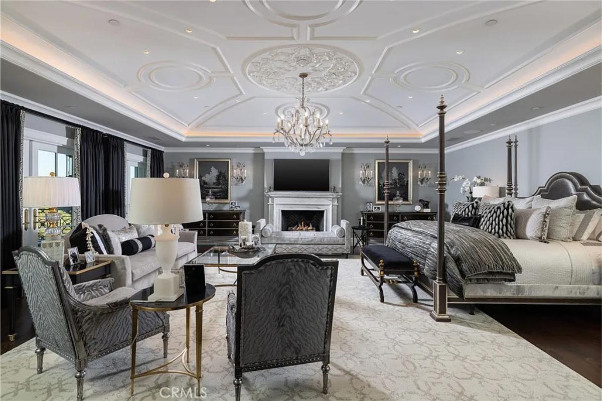 Bedroom with a living space, a chandelier and a fireplace.