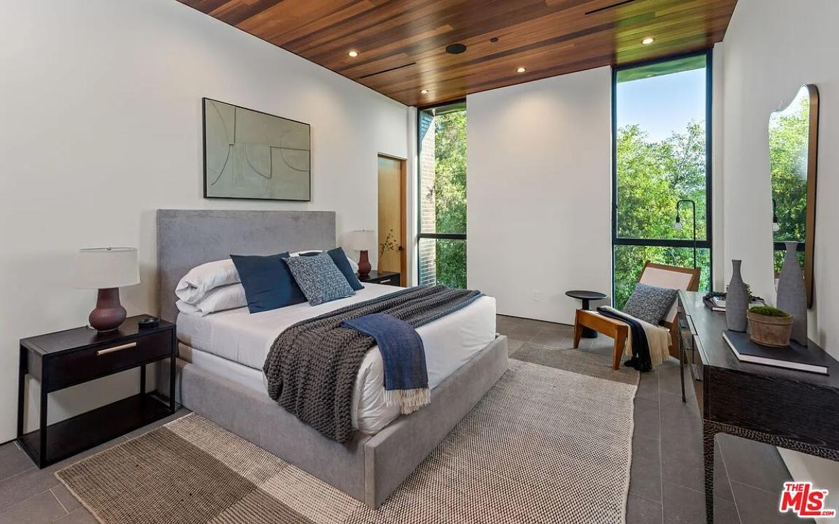 Bedroom with a large bed and glass windows.