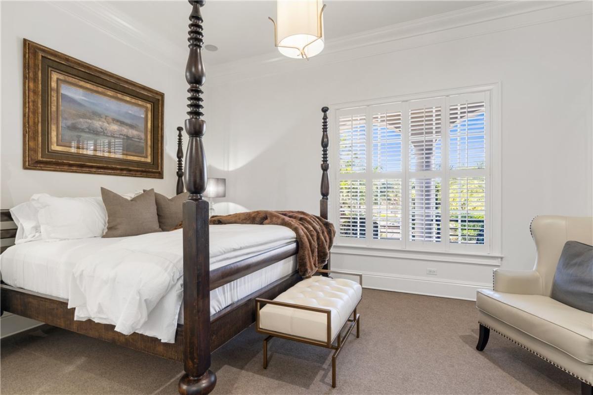 Bedroom with a large bed and carpet flooring.