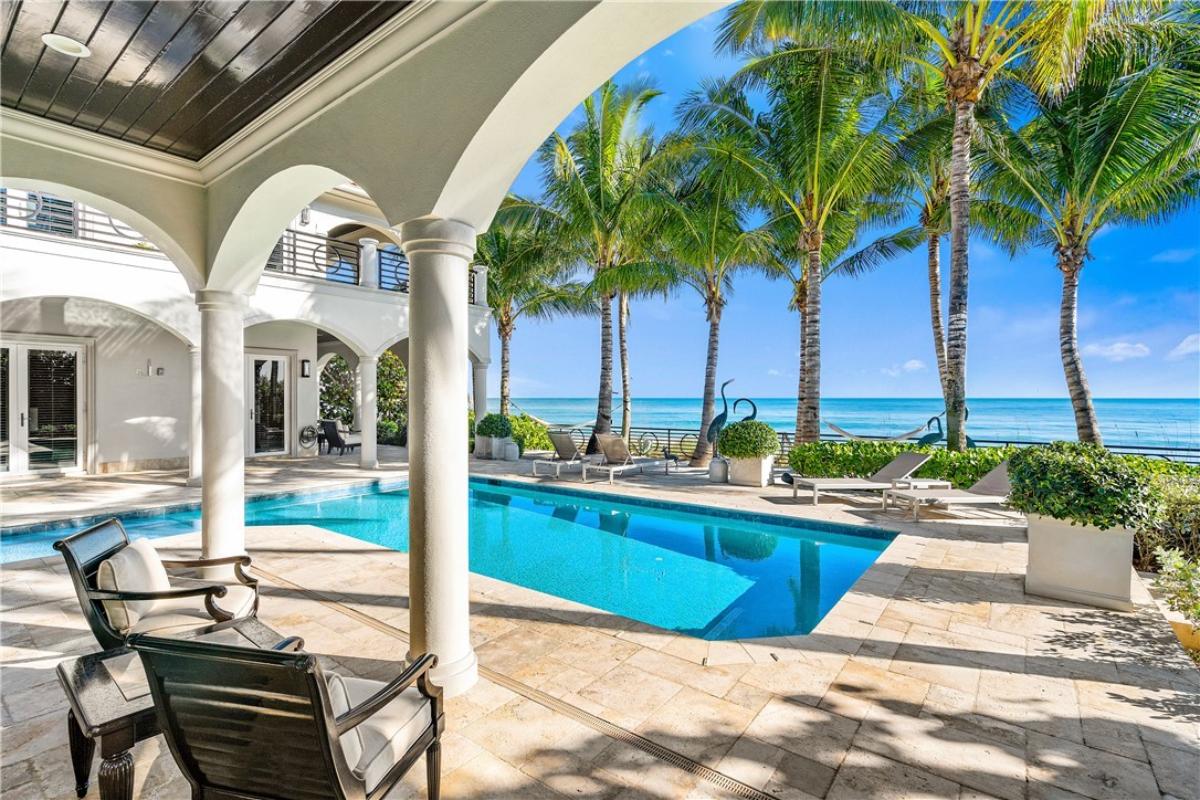 Pool with lounge chairs and ocean views.