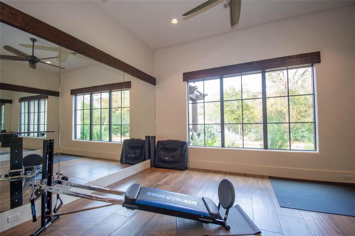 Home gym with hardwood flooring.