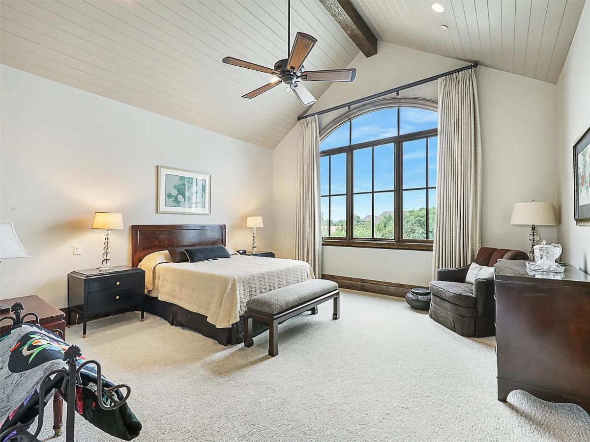 Bedroom with a large bed and carpet flooring.