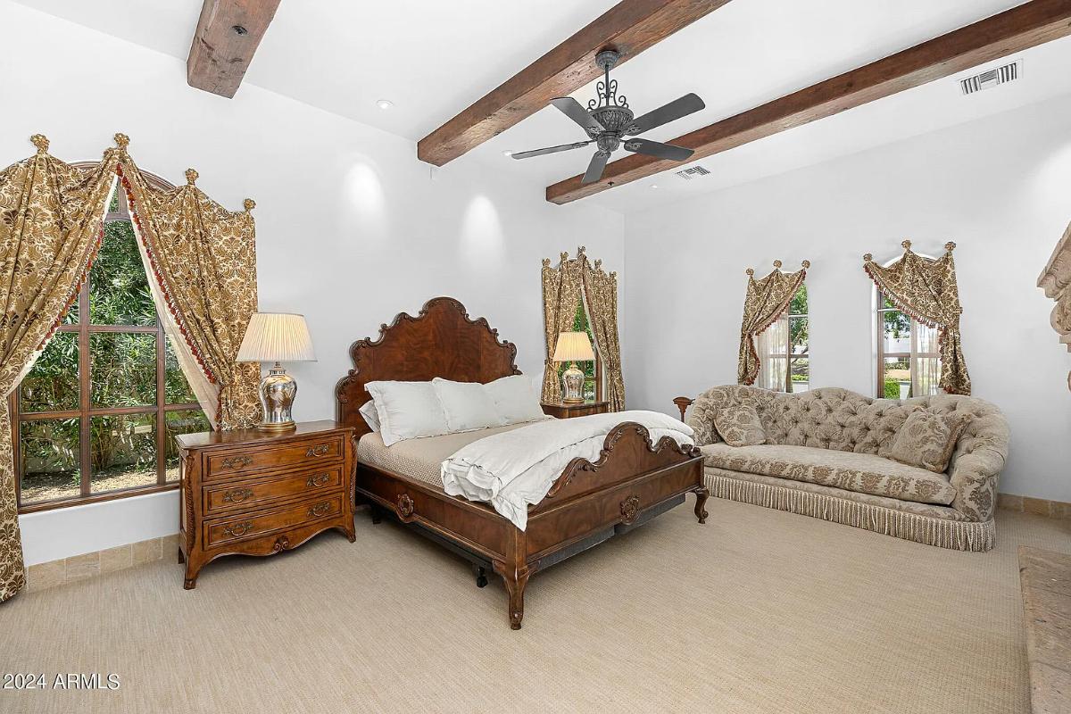 Bedroom with a large bed and carpet flooring.
