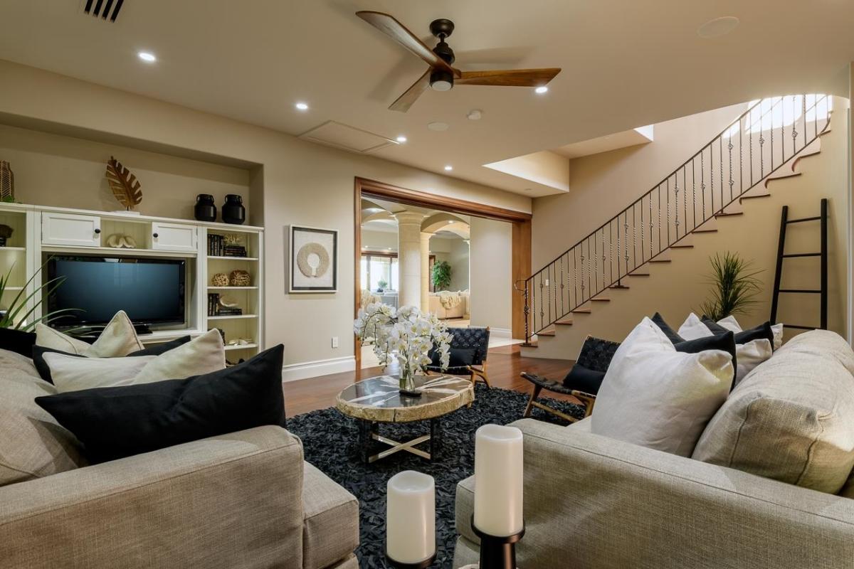 Living room with couches and a ceiling fan.