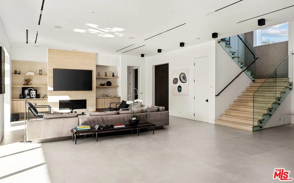 Living room with couches, TV and a fireplace.