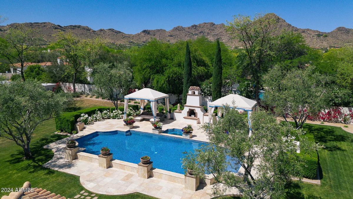 Pool with cabanas and a fireplace.