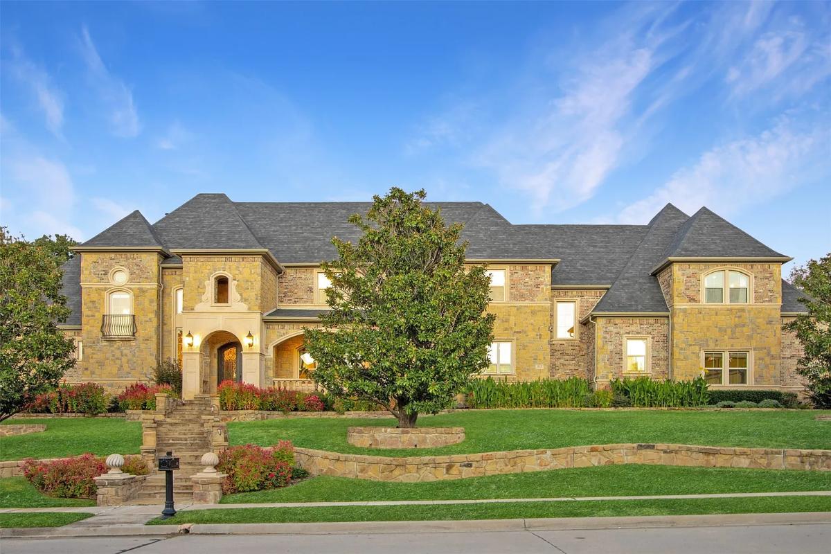 Front view of the mansion with a large green lawn.