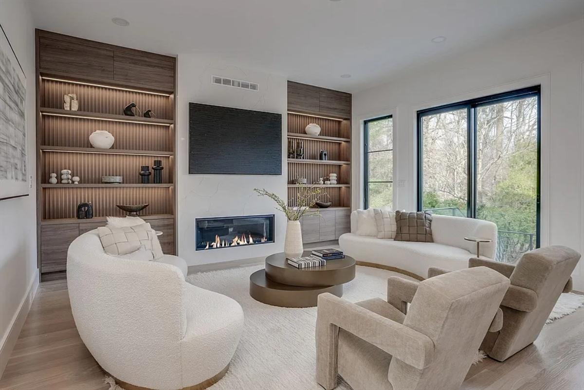 Living room with couches, hardwood floors and a fireplace.